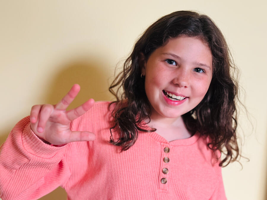 Eleanor smiling and making an eagle talon gesture